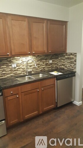 A kitchen with wooden cabinets and a stone backsplash.