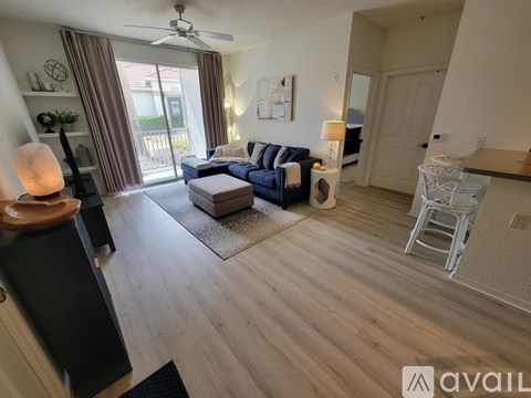 A living room with a blue couch and a fan.