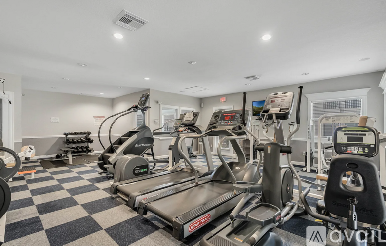 A gym with a treadmill, elliptical machines, and other exercise equipment.