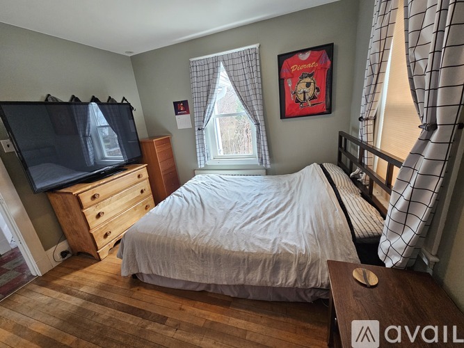 A bedroom with a bed, dresser, and window.