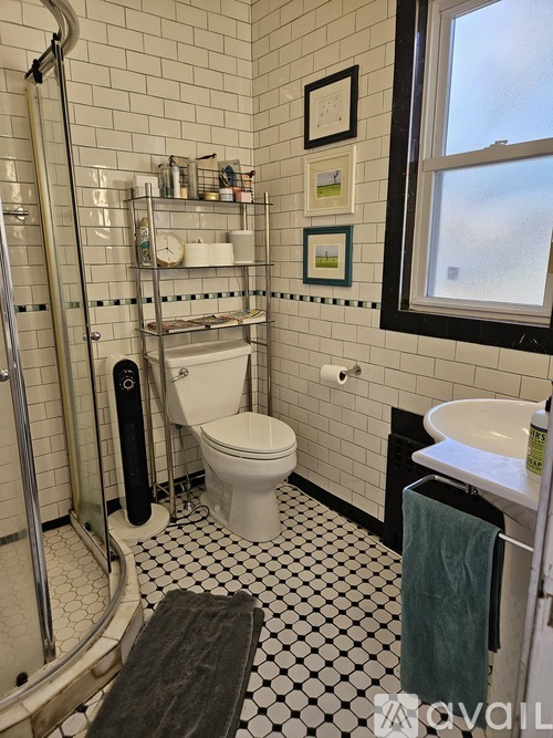 A bathroom with a white toilet, sink, and a window.