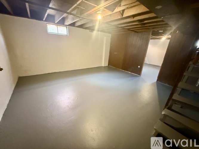 A room with a wooden door and a window on the wall.