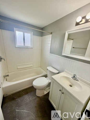 A bathroom with a white toilet, sink, and bathtub.