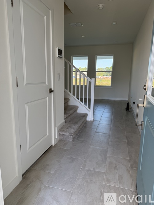 A hallway with a staircase leading to a balcony.