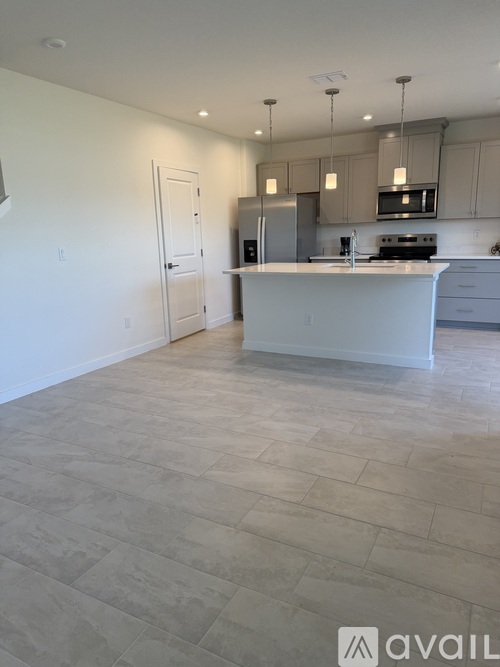A kitchen with a white island and a white door.