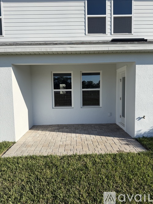 A white house with a wooden walkway leading to the front door.