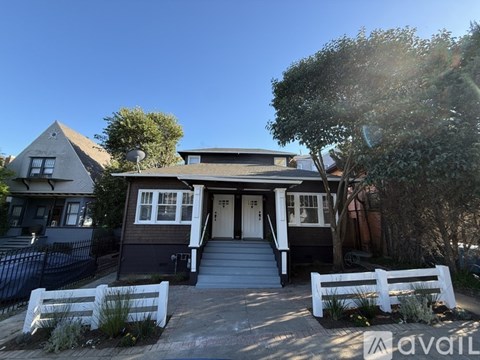 A house with a white picket fence in front.