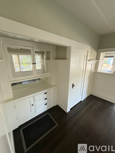 A kitchen with white cabinets and a black floor mat.