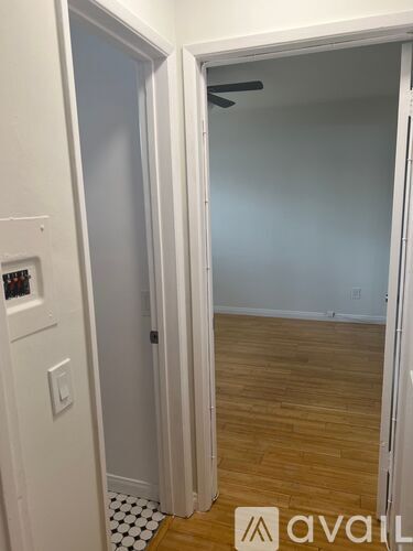 A room with a wooden floor and a white door.