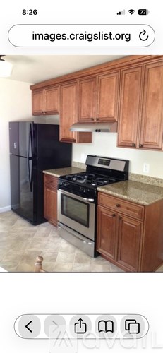 A kitchen with wooden cabinets and black appliances.