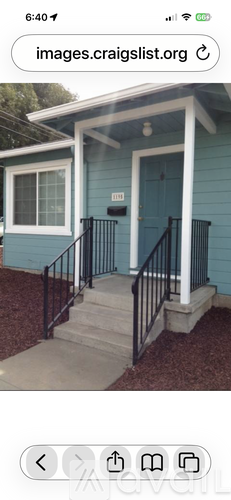 A blue house with a white porch and black railings.