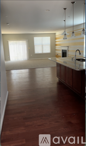 A kitchen with wooden floors and a striped wall.