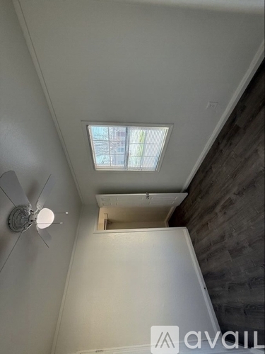 A ceiling fan in a room with a skylight.