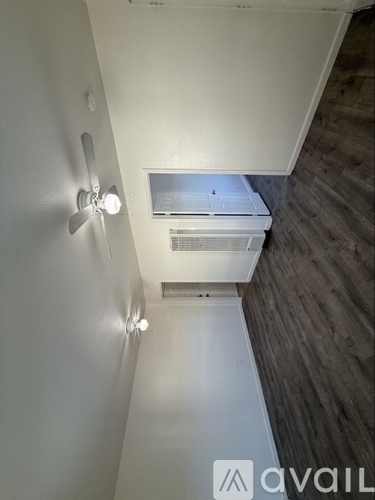 A white wall with a ceiling fan and lights.