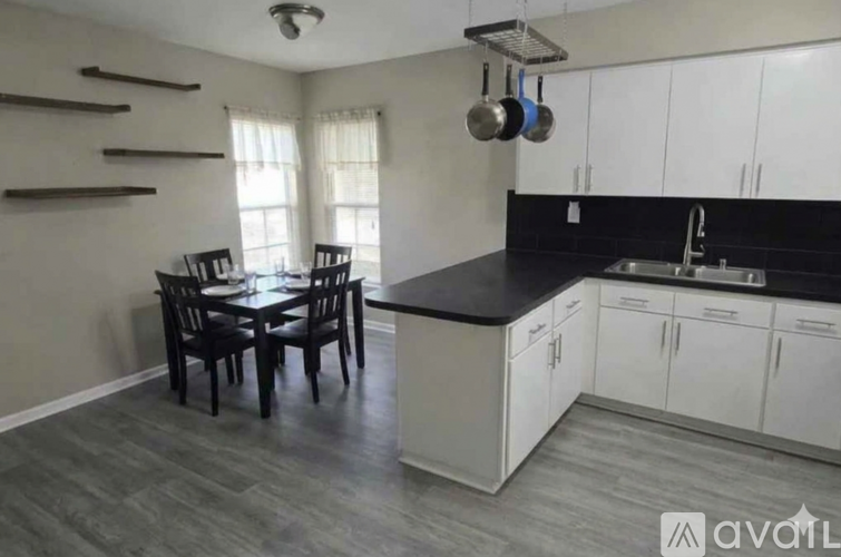 A kitchen with a dining table and chairs.