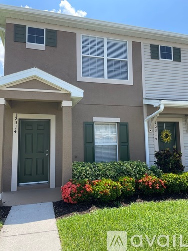 A house with a green door and a white garage door.