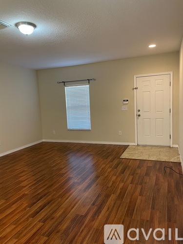 A room with wooden flooring and a white door.