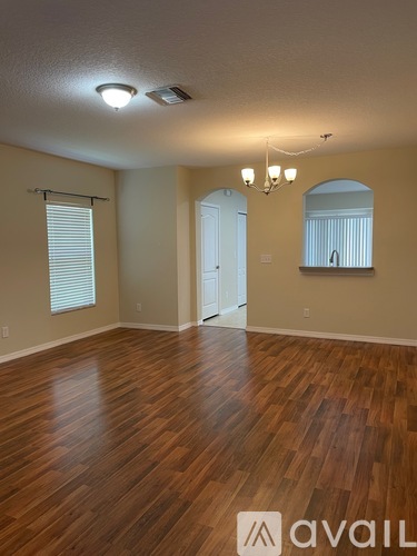 A room with wooden flooring and a chandelier.