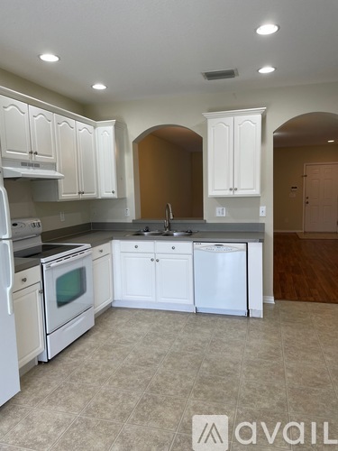 A kitchen with white cabinets and appliances.