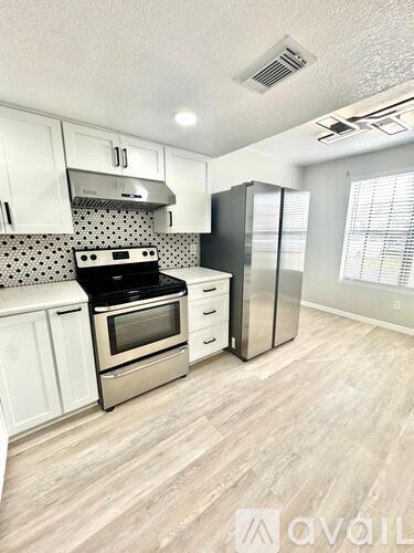 A kitchen with white cabinets and a black stove top oven.