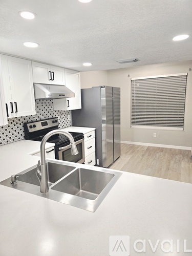 A kitchen with a sink, stove, and refrigerator.