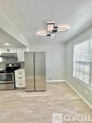 A kitchen with a refrigerator, microwave, and oven.
