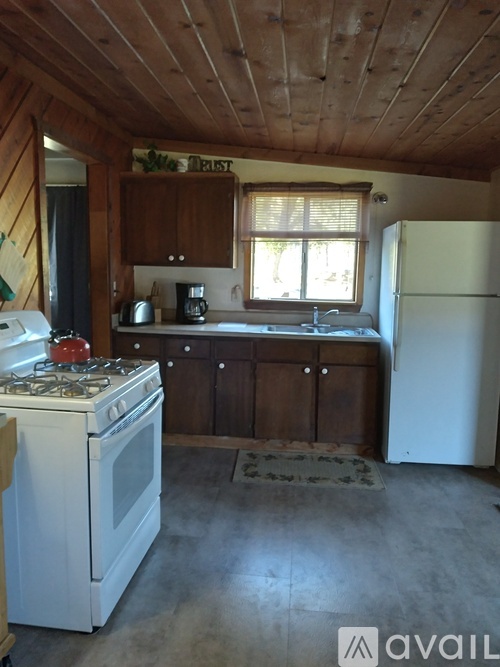 A kitchen with a white stove and wooden cabinets.