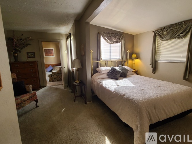 A bedroom with a large bed and a dresser.