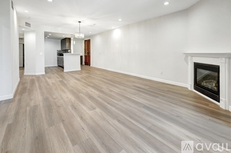 A spacious living room with a fireplace and hardwood flooring.