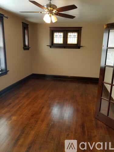 A room with wooden floors and a ceiling fan.