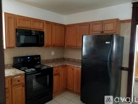 A kitchen with wooden cabinets and black appliances.