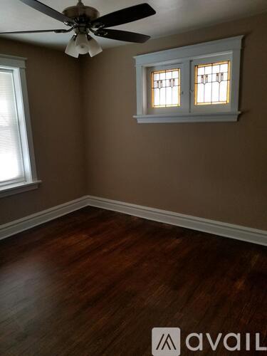 A room with a ceiling fan and wooden flooring.