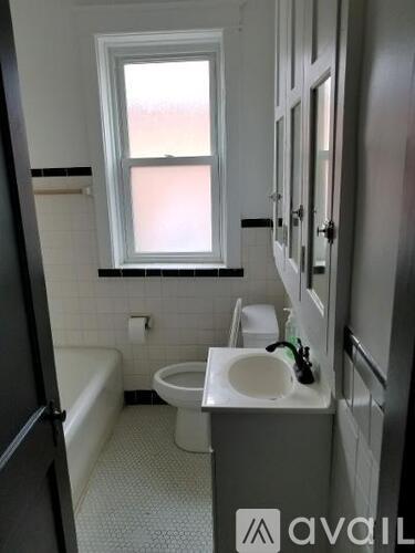 A bathroom with a toilet, sink and tub.