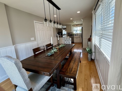 A dining room with a wooden table and chairs.