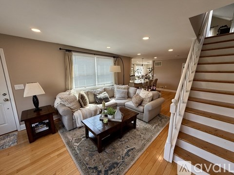 A living room with a staircase on the right side.