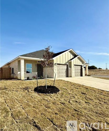 A house with a brown roof and a tree in front of it.