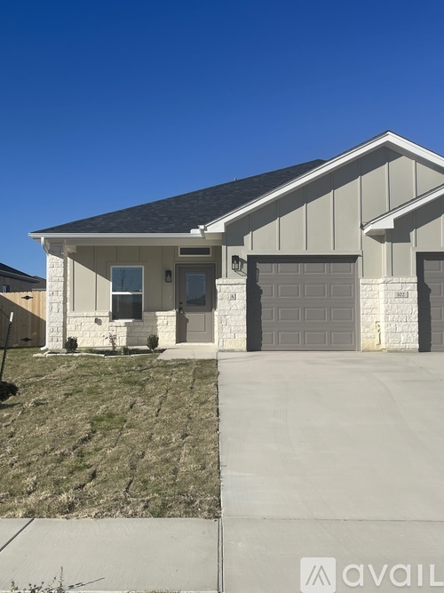 A house with a grey roof and a garage door.