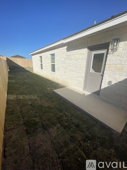 A house with a white door and windows is shown with a grassy yard.