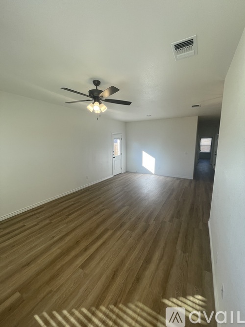 A room with wooden flooring and a ceiling fan.