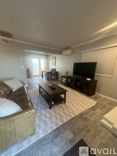 A living room with a couch, coffee table, and television.