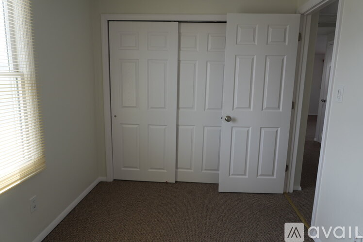 A room with a white door and carpeted floor.