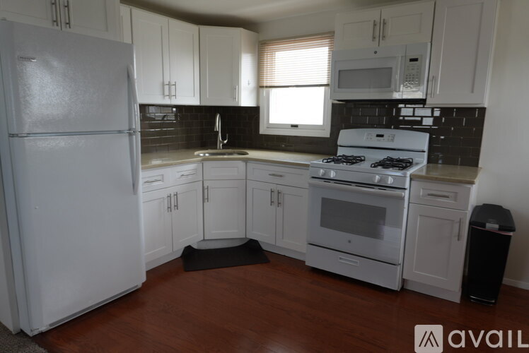 A kitchen with white appliances and cabinets.