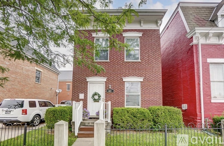 A red brick house with a white door and a garage.