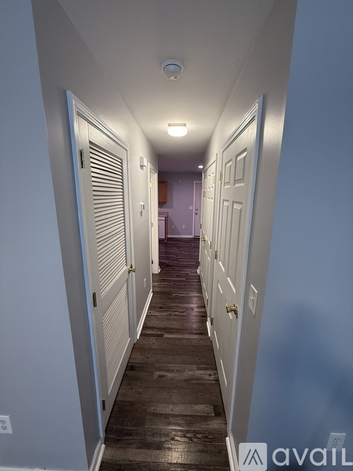 A long hallway with white doors on both sides.