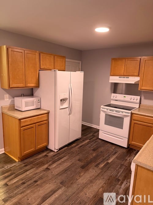 A kitchen with wooden cabinets and white appliances.