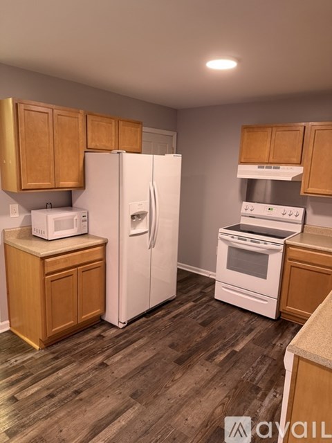 A kitchen with wooden cabinets and white appliances.