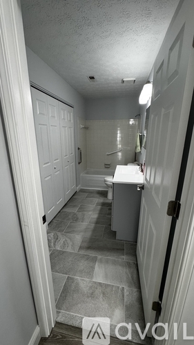 A hallway with a tile floor and a white door.