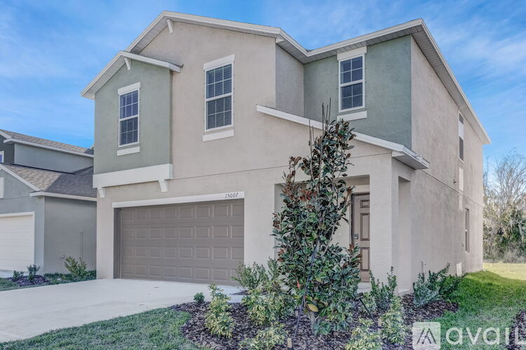 A two-story house with a garage is available for sale.