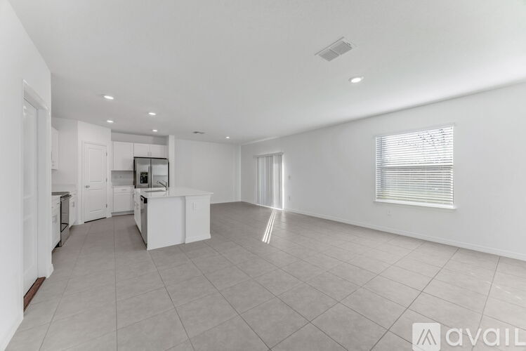 A spacious, empty room with white walls and a tiled floor.