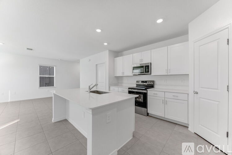 A modern kitchen with white cabinets and appliances.